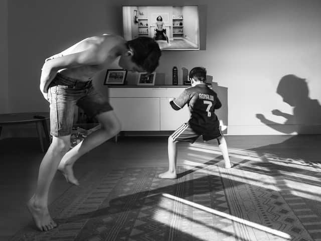 Photo issued by Historic England from their Picturing Lockdown Collection by Francesca Brecciaroli showing children taking part in the Joe Wicks PE sessions in the living room of their home in Beckenham, south London.