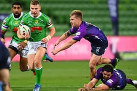Canberra Raiders' George Williams gets by Melbourne Storm's Cameron Munster on Sunday in Melbourne. Picture: Quinn Rooney/Getty Images