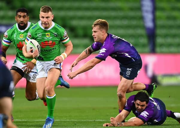 Canberra Raiders' George Williams gets by Melbourne Storm's Cameron Munster on Sunday in Melbourne. Picture: Quinn Rooney/Getty Images