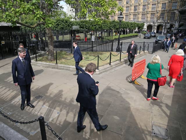 Commons leader Jacob Rees-Mogg (left) ques to take part in a division on Tuesday.