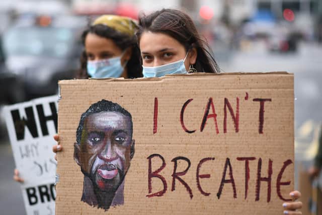 People hold banners during a Black Lives Matter protest rally as it passes near to Victoria station, London, in memory of George Floyd who was killed on May 25 while in police custody in the US city of Minneapolis.