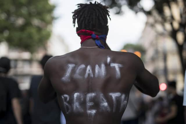 A protester wears the words "I Can't Breathe" painted on his back in Marseille, southern France, Saturday, June 6, 2020, to protest against the death of George Floyd. Floyd, a black man, died after he was restrained by police officers.