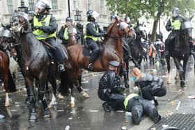 An injured police officer is tended to after a police charge on horseback charge in Whitehall following a Black Lives Matter protest rally in Parliament Square, London. Picture: Yui Mok/PA Wire