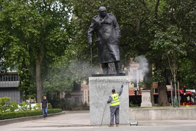 A worker cleans graffiti from the plinth of the statue of Sir Winston Churchill at Parliament Square in London, following a Black Lives Matter protest at the weekend.