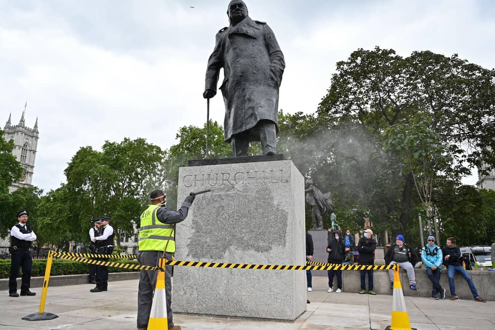 The statue of former British prime minister Winston Churchill is cleaned in Parliament Square, central London on June 8, 2020, after being defaced, with the words (Churchill) "was a racist" written on it's base by protesters at a demonstration on June 7, 2020, organised to show solidarity with the Black Lives Matter movement. - Most marches at the weekend were peaceful but there were flashes of violence, including in London, where the statue of World War II leader Winston Churchill in Parliament Square was defaced.