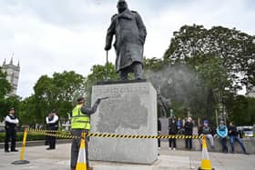The statue of former British prime minister Winston Churchill is cleaned in Parliament Square, central London on June 8, 2020, after being defaced, with the words (Churchill) "was a racist" written on it's base by protesters at a demonstration on June 7, 2020, organised to show solidarity with the Black Lives Matter movement. - Most marches at the weekend were peaceful but there were flashes of violence, including in London, where the statue of World War II leader Winston Churchill in Parliament Square was defaced.