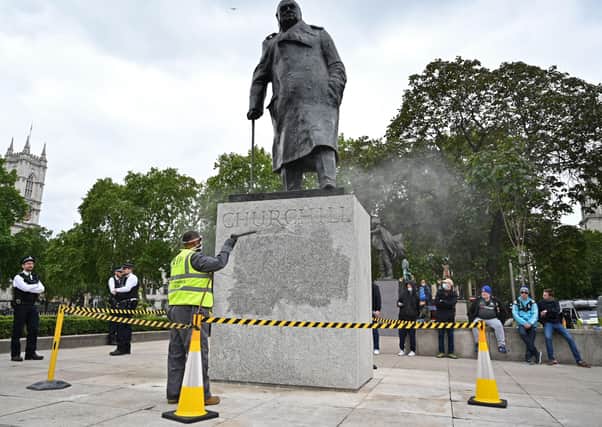 The statue of former British prime minister Winston Churchill is cleaned in Parliament Square, central London on June 8, 2020, after being defaced, with the words (Churchill) "was a racist" written on it's base by protesters at a demonstration on June 7, 2020, organised to show solidarity with the Black Lives Matter movement. - Most marches at the weekend were peaceful but there were flashes of violence, including in London, where the statue of World War II leader Winston Churchill in Parliament Square was defaced.