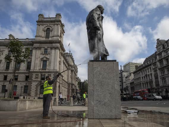 A worker cleans the defaced Churchill statue in Parliament Square. (Picture: Getty Images).