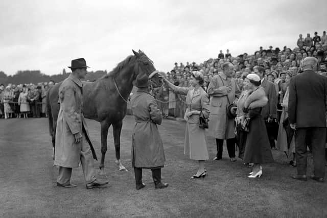 The Queen smiles and gives her four year old colt Aureole a congratulatory pat on the nose after his victory in the King George VI and the Queen Elizabeth Stakes at Ascot