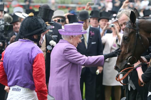 The Queen pats her horse Estimate after it won the Gold Cup ridden by jockey Ryan Moore in 2013