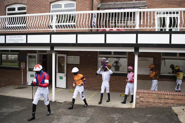 The jockeys walk out of the weighing room at Pontefract Racecourse.