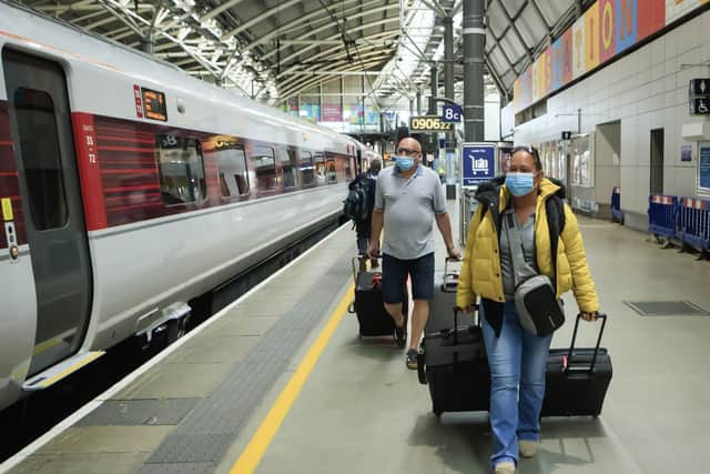 Passengers get on a train in Leeds while wearing a protective face mask. Pic: PA