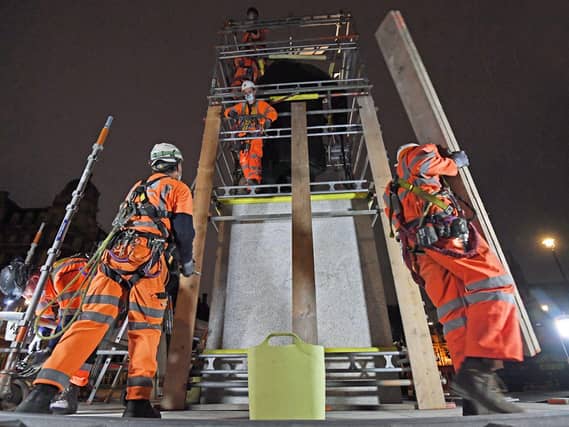 Scaffolders erect boarding around the statue of Sir Winston Churchill in Parliament Square, London. Photo: PA