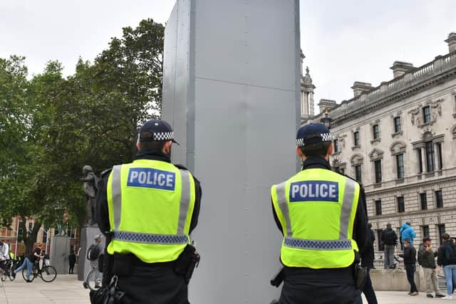 Police officers stand beside a boxed up statue of Sir Winston Churchill in Parliament Square, London, as people participate in a Black Lives Matter protest. Photo: PA