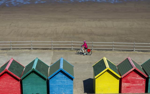 A lone cyclist passes the beach huts on Whitby's West Cliff during lockdown in April.  Picture Tony Johnson