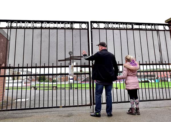 WHAT SHOULD HAVE BEEN: Cricket fans peer through the gates at Scarborough CC, beyond which they should have been watching the first Roses County Championship clash between Yorkshire and Lancashire at the venue since 1991. Picture: Richard Ponter