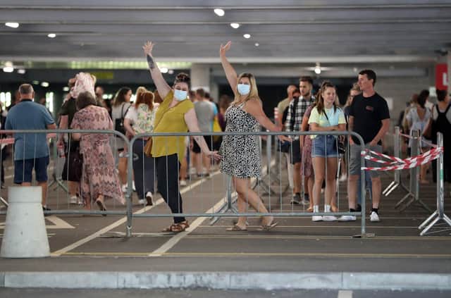 Members of the public wearing face masks pose for a photo as they queue to go into Ikea Milton Keynes on the first day of reopening on June 1. (Photo by Catherine Ivill/Getty Images)
