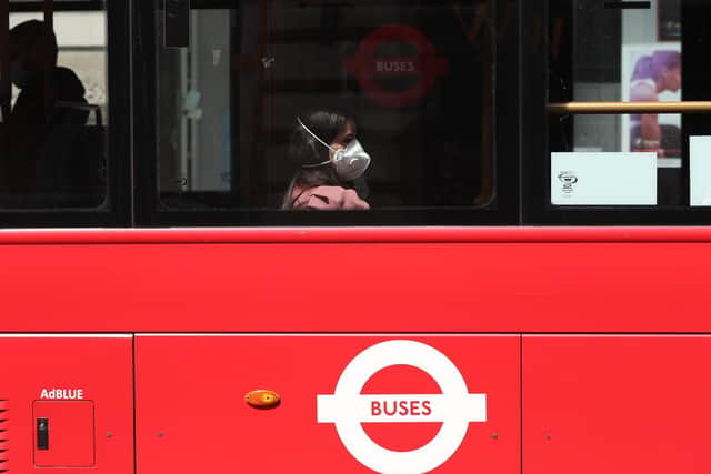 A person wearing a face mask rides a bus on Piccadilly, London, following the introduction of measures to bring England out of lockdown. Photo: PA