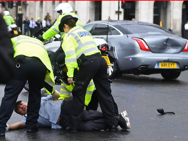 Police detain a man after he ran in front of Prime Minister Boris Johnson's car as it left the Houses of Parliament, Westminster. The man, who had been demonstrating about Turkey's operation against Kurdish rebels in northern Iraq, was taken into the Palace of Westminster by officers. Photo: PA