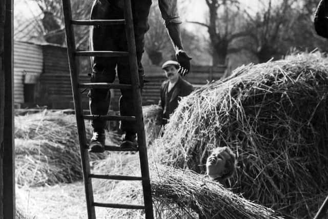 3rd April 1947:  Young boy helping a thatcher on the farm at Woodmancete, Gloucestershire.  (Photo by Maeers/Fox Photos/Getty Images)