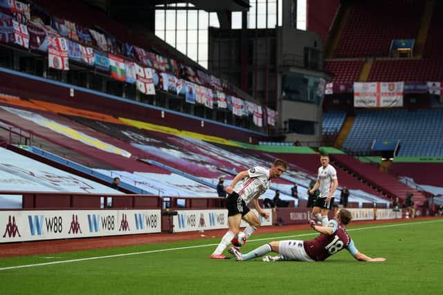 Sheffield United's Chris Basham is tackled by Aston Villa's Matt Targett in front of the empty stands at Villa Park (Picture: PA)