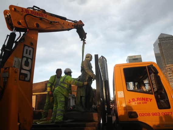 Workers take down a statue of slave owner Robert Milligan at West India Quay, east London after a protest saw anti-racism campaigners tear down a statue of a slave trader in Bristol.