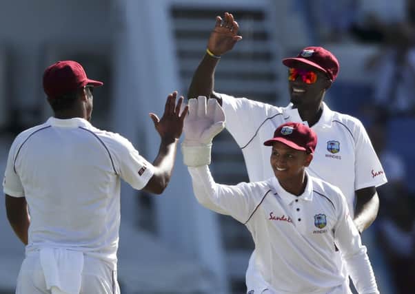 West Indies' captain Jason Holder, back right, and wicket keeper Shane Dowrich celebrate with Shannon Gabriel, left, after the dismissal of England's Moeen Ali in January 2019. AP/Ricardo Mazalan