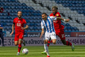 Action resumes: Huddersfield Town's Karlan Grant bursts past Wigan's Cedric Kipre. 
Pictures: Tony Johnson