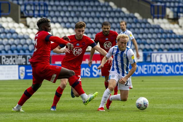 No room: Huddersfield's Alex Pritchard is closed down by the Wigan defence.