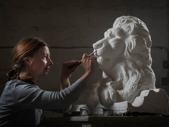 Carver Kibby Schaefer works on a plaster model of Aslan, a character from the children's book series The Chronicles of Narnia