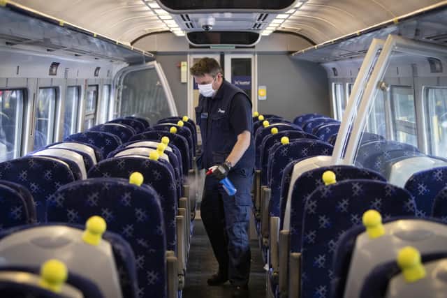 A member of the cleaning team disinfects the inside of a train carriage as lockdown restrictions are eased back.