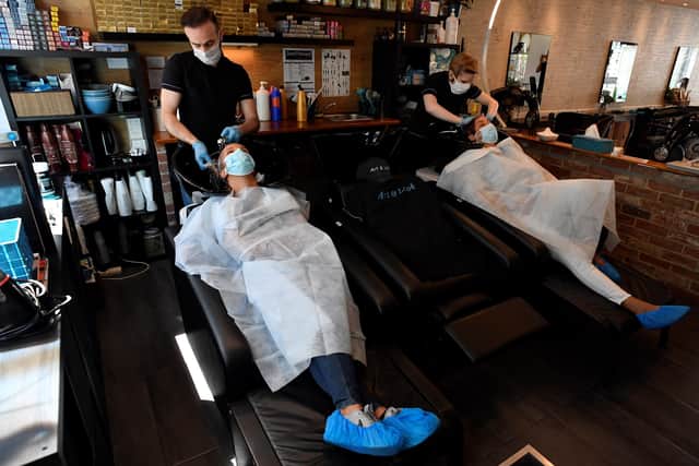Women get a haircut at the "Hair & Look" salon, in  Belgium eases lockdown measures which are set to follow in the UK from July 4 Photo by JOHN THYS / AFP