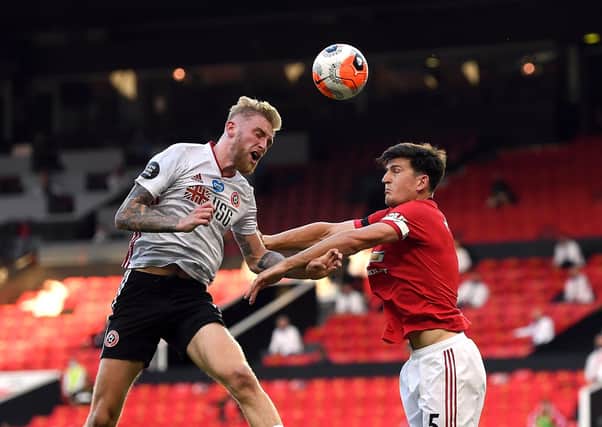 Sheffield United's Oliver McBurnie (left) and Manchester United's Harry Maguire battle for the ball (Picture: PA)