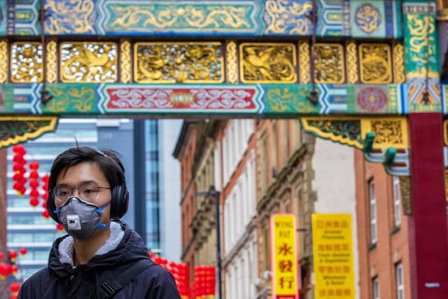A man pictured wearing a face covering in Chinatown, Manchester, in January this year as hate crimes against Chinese people rose in the early days of the coronavirus pandemic