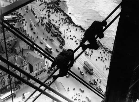 15th August 1934:  Workmen balanced high above the street and the beach on the struts of Blackpool Tower in Blackpool during repair work.  (Photo by Fox Photos/Getty Images)