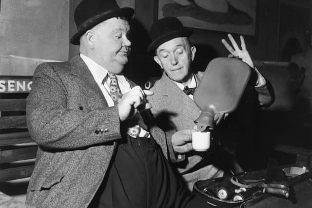 Comedy duo Stan Laurel (1890 - 1965) and Oliver Hardy (1892 - 1957) share an impromptu cup of coffee at a railway station in the sketch 'A Spot Of Trouble', performed on stage during their tour of the UK, 25th February 1952. The plot was a reworking of their 1930 comedy short 'Night Owls'.  (Photo by John Pratt/Keystone Features/Getty Images)