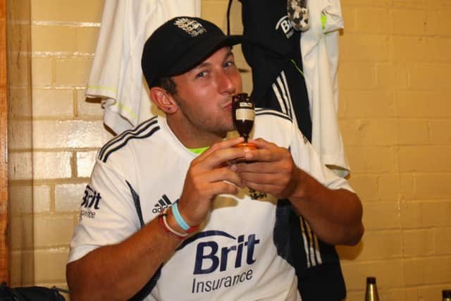 England's Tim Bresnan celebrate in the dressing room with the Ashes urn.