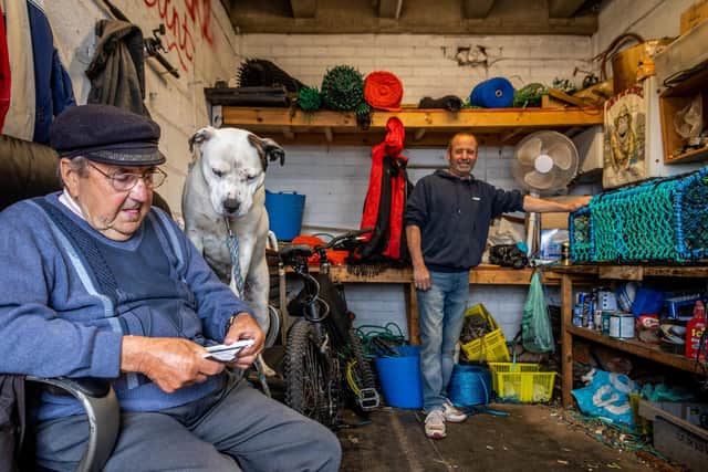 Rolly Rollisson, 91, sat near son Rolo's pet dog Sky in the shed where Rolo makes hundreds of lobster pots for the shellfishing boat Elsie B