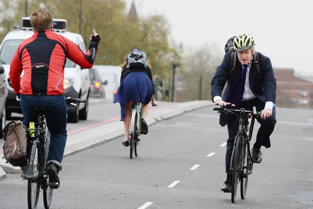 A cyclist gestures to Boris Johnson, the then Mayor of London, in 2015 on Westminster Bridge.