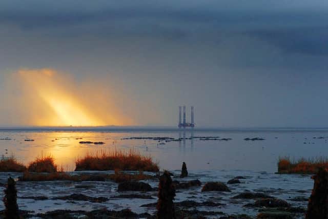 8 November 2009....... Picture Post..... View from Kilnsea over the Spurn Peninsular as the sun breaks through the clouds by the oil gas drilling rig in the Humber Estuary. Nikon D2h 400ISO 70mm lens 125th @f9 Pic:	Tony Johnson