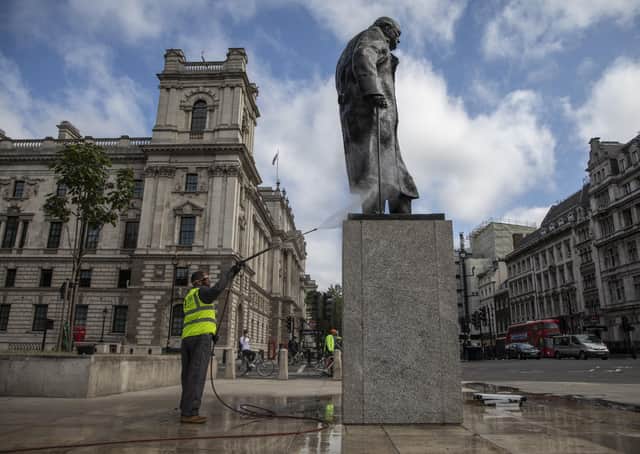 A worker cleans Winston Churchill's statue in Parliament Square.