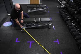 Operations manager Graham Lilley measures out the distances between benches in the weights area at the Anytime Fitness gym centre in Leeds (photo: SWNS).