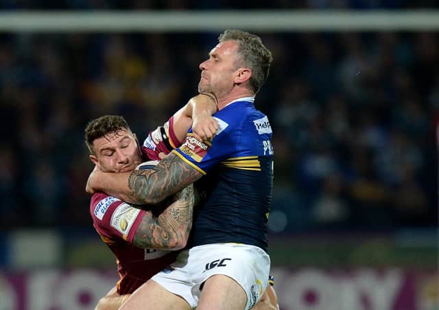 Huddersfield Giants Jamie Ellis is tacked by Leeds Rhinos Carl Ablett (left) and Jamie Peacock (right), during the First Utility Super League, Super 8s match at The John Smiths Stadium, Huddersfield. PRESS ASSOCIATION Photo. Picture date: Friday September 25, 2015. See PA story RUGBYL Huddersfield. Photo credit should read: Martin Rickett/PA Wire. RESTRICTIONS: Editorial use only. No commercial use. No false commercial association. No video emulation. No manipulation of images.