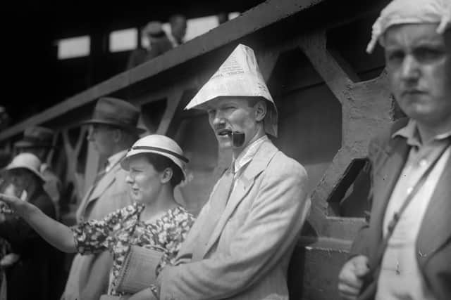 July 1935:  Spectators standing at No 1 court, Wimbledon are wearing newspapers folded into hats and knotted handkerchiefs as protection against the sun.  (Photo by General Photographic Agency/Getty Images)