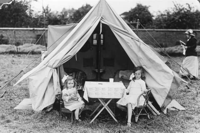 19th December 1915:  Two little girls sit outside their tent at the Caravan Club Annual Meet at Stratford on Avon.  (Photo by Topical Press Agency/Getty Images)