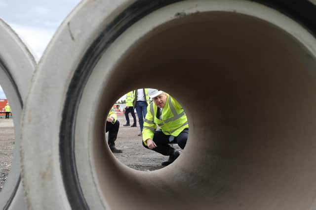 Prime Minister Boris Johnson looks through a large bore pipe during a visit to the Siemens Rail factory construction site in Goole.
