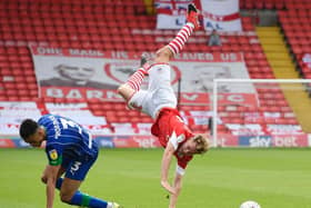 Barnsley defender Kilian Ludewig is sent spinning in the air by a reckless challenge from Wigan's Antonee Robinson. PICTURE: George Wood/Getty Images