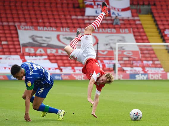 Barnsley defender Kilian Ludewig is sent spinning in the air by a reckless challenge from Wigan's Antonee Robinson. PICTURE: George Wood/Getty Images
