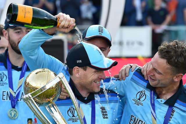England's captain Eoin Morgan (C) holds the World Cup trophy as he celebrates with England's Jason Roy (2L), and England's Jos Buttler after winning the 2019 Cricket World Cup final between England and New Zealand at Lord's Cricket Ground in London on July 14, 2019. - England won the World Cup for the first time as they beat New Zealand in a Super Over after a nerve-shredding final ended in a tie at Lord's on Sunday. (Photo by Glyn KIRK / AFP) / RESTRICTED TO EDITORIAL USE        (Photo credit should read GLYN KIRK/AFP via Getty Images)