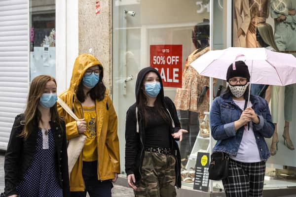 A group of young women walk through Belfast City CentreÍs shopping district wearing face masks on the day it was announced face masks will become mandatory in shops in England. Picture: Liam McBurney/PA Wire